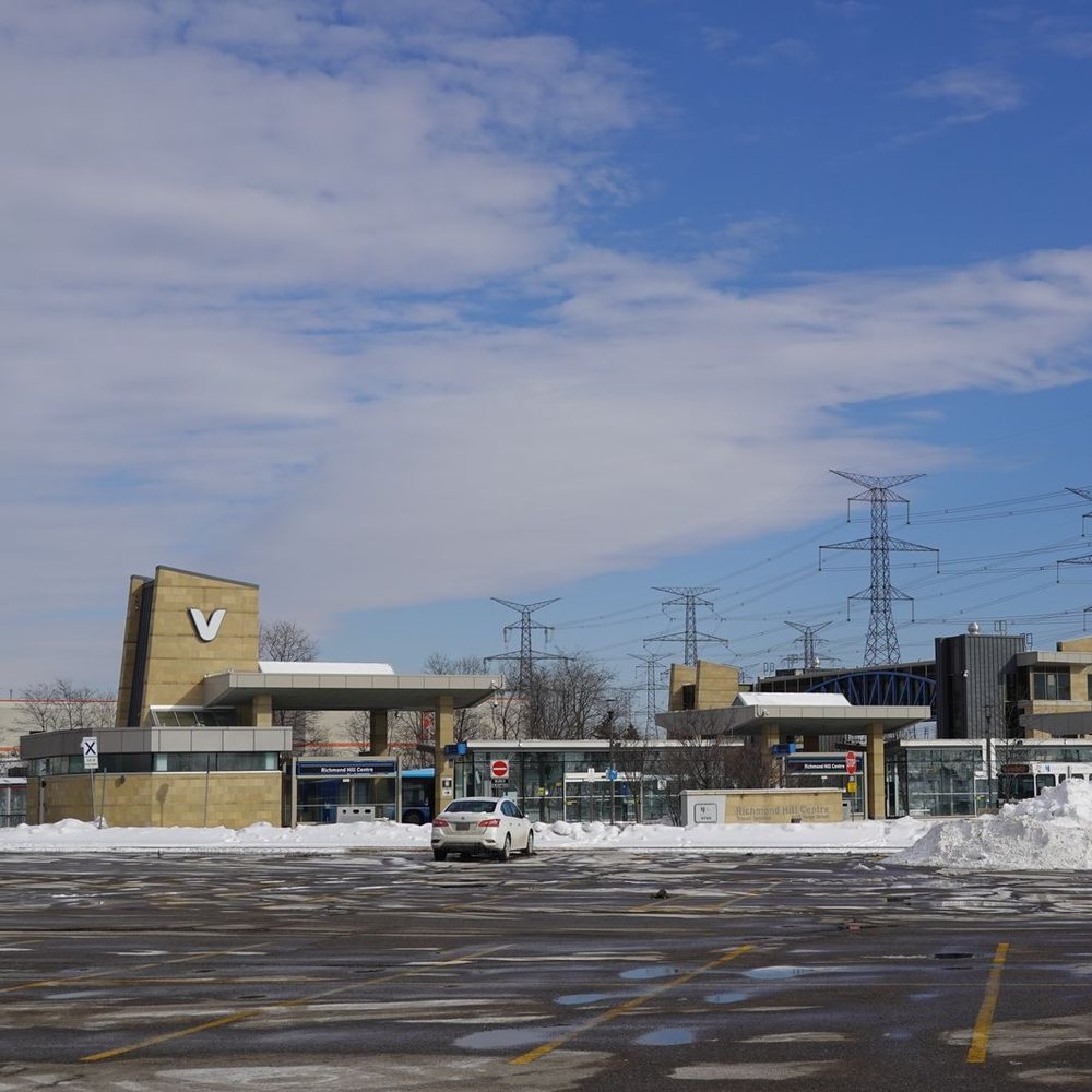 Commercial parking lot after snow clearing with buildings and power lines behind